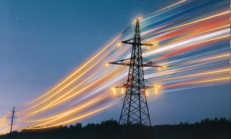 Power transmission tower with light trails at dusk